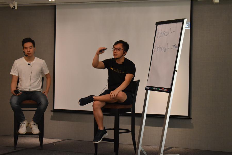 Marc teaching at a flip chart, arms open.