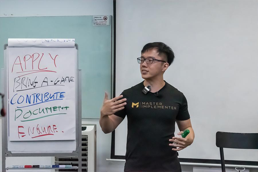 Marc teaching by a flip chart in an MI tee.