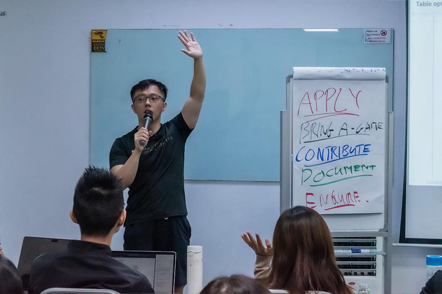 Marc teaching with his arm raised.