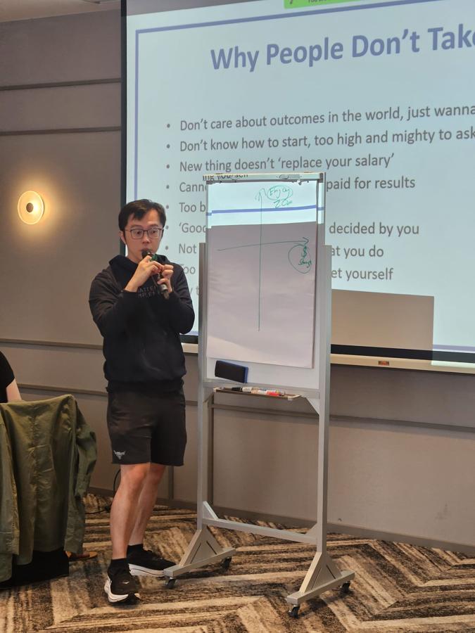 Marc teaching at the flip chart in an MI hoodie.