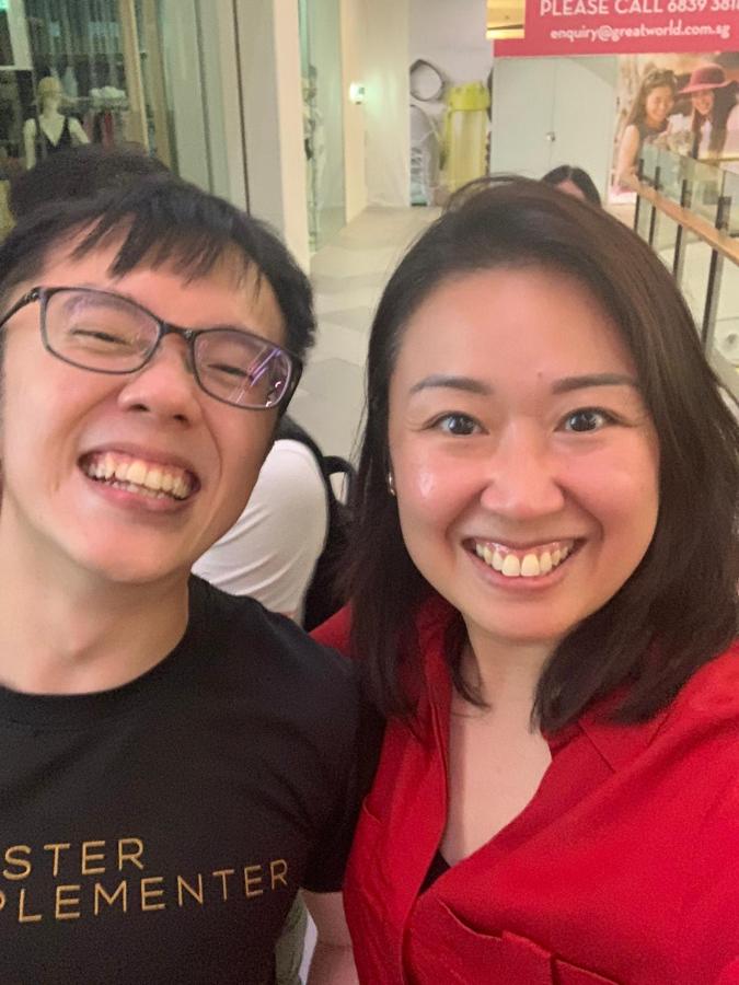 Marc smiling with a client, MI tee on.
